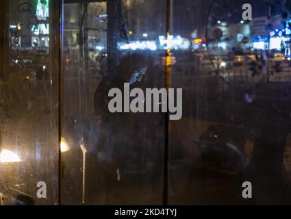 Un uomo iraniano utilizza il suo smartphone mentre si trova in piedi presso un'area di sosta degli autobus vicino a un santuario sacro nella città Santa di Qom 145km (90 miglia) a sud di Teheran di notte il 10 marzo 2022. (Foto di Morteza Nikoubazl/NurPhoto) Foto Stock