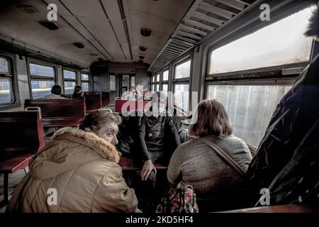 Un vecchio uomo con un facemask in attesa in treno. Popolo ucraino, rifugiati di guerra come si vede in una vecchia ferrovia auto entrare velocemente dopo l'attesa metropolitana a Lviv stazione ferroviaria passaggio il treno per arrivare e salire a bordo delle carrozze perché la stazione è considerata come un obiettivo militare. Il treno attraverserà le frontiere ucraine polacche e si sposterà ulteriormente verso la Polonia e altri paesi europei. Il 15 marzo le sirene per RAID aereo suonavano due volte, una al mattino e una alla sera. Secondo le Nazioni Unite - UNHCR più di 3,3 milioni di rifugiati hanno lasciato il paese come annunciato dalle Nazioni Unite Foto Stock