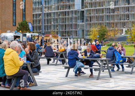 Le persone si siedono ai tavoli da picnic mangiando cibo di strada dal Duck Truck & Halloumi Bite di fronte alla centrale elettrica di Battersea, Wandsworth, Londra. Foto Stock