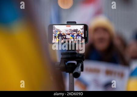 I manifestanti registrano un saluto per la Guardia Nazionale Ucraina nel suo ottavo anniversario durante un rally che segna un mese dall'inizio dell'invasione russa. I dimostranti chiedono una zona di interdizione aerea e la rimozione di tutte le banche russe da SWIFT. L'evento è stato sponsorizzato da attivisti ucraini statunitensi, un'organizzazione statunitense di assistenza e difesa. (Foto di Allison Bailey/NurPhoto) Foto Stock