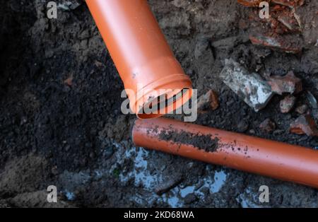 Riparazione dello scarico delle fognature con un robusto tubo in plastica di grande diametro in un'area aperta Foto Stock