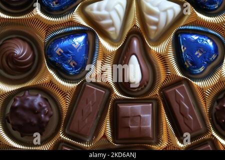 Vantaa, Finlandia, dicembre 2019: Confezione di pregiate praline al cioccolato Swiss Lindt in una scatola d'oro. Colore primo piano dall'alto. Chocos bianchi, scuri e al latte Foto Stock