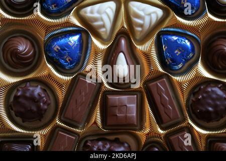 Vantaa, Finlandia, dicembre 2019: Confezione di pregiate praline al cioccolato Swiss Lindt in una scatola d'oro. Colore primo piano dall'alto. Chocos bianchi, scuri e al latte Foto Stock