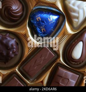 Vantaa, Finlandia, dicembre 2019: Confezione di pregiate praline al cioccolato Swiss Lindt in una scatola d'oro. Colore primo piano dall'alto. Chocos bianchi, scuri e al latte Foto Stock