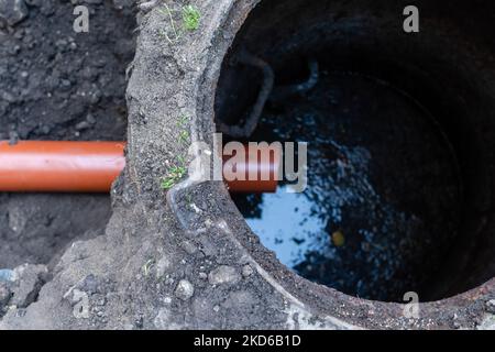 Riparazione dello scarico delle fognature con un robusto tubo in plastica di grande diametro in un'area aperta Foto Stock