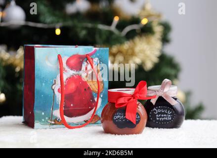 Espoo, Finlandia, 2019 dicembre: Borsa regalo di Natale di Babbo Natale a tema e due marmellate fatte in casa in vasetti di vetro decorati con archi rossi. Foto Stock