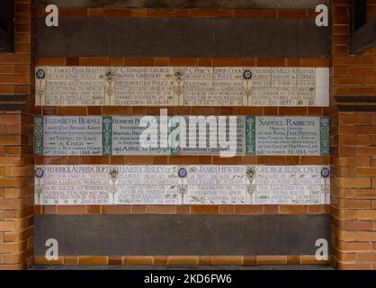 Un primo piano di targhe informative del Watts Memorial nel Postman's Park di Londra, Inghilterra Foto Stock