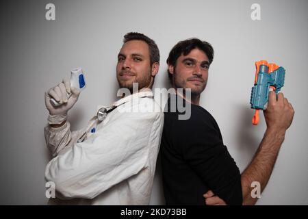 Il medico e il paziente giocano, il medico con il termometro a pistola e il paziente con una pistola giocattolo. Foto Stock