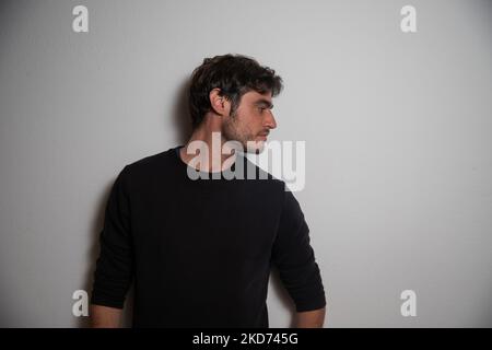 Ritratto di un giovane caucasico nel suo 30s appoggiato al muro in studio. Foto Stock