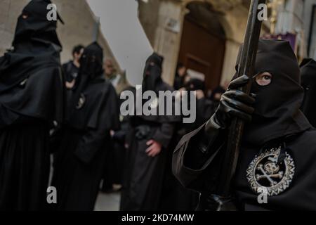 Membro dell'Arciconfraternita di morte del sacco nero incappucciati durante la processione dell'Addolorata a Molfetta il 8 aprile 2022. Dopo due anni di sosta a causa del Covid-19, Molfetta torna oggi ad assaporare l'atmosfera delle tradizionali processioni pasquali e dei riti. Dalla Chiesa di Santa Maria degli Affliti inizia la processione dell'Addolorata: I portieri dell'Arciconfraternita di morte del sacco nero portarono la statua della Madonna sulle spalle della città (Foto di Davide Pischettola/NurPhoto) Foto Stock