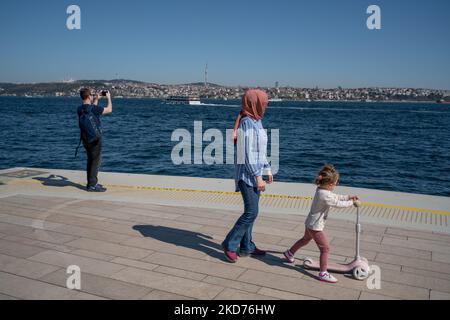 La gente cammina al porto di Galatport e guarda il Bosforo il 9 aprile 2022, a Istanbul, in Turchia. Situato nel quartiere Karakoy di Istanbul, il Galatport è stato progettato come un moderno porto per le grandi navi da crociera. Gli edifici storici restaurati fungono ora da ristoranti, negozi di abbigliamento e musei. (Foto di Erhan Demirtas/NurPhoto) Foto Stock