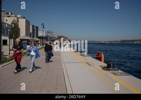 La gente cammina al porto di Galatport e guarda il Bosforo il 9 aprile 2022, a Istanbul, in Turchia. Situato nel quartiere Karakoy di Istanbul, il Galatport è stato progettato come un moderno porto per le grandi navi da crociera. Gli edifici storici restaurati fungono ora da ristoranti, negozi di abbigliamento e musei. (Foto di Erhan Demirtas/NurPhoto) Foto Stock