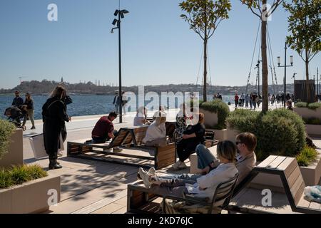 La gente cammina al porto di Galatport e guarda il Bosforo il 9 aprile 2022, a Istanbul, in Turchia. Situato nel quartiere Karakoy di Istanbul, il Galatport è stato progettato come un moderno porto per le grandi navi da crociera. Gli edifici storici restaurati fungono ora da ristoranti, negozi di abbigliamento e musei. (Foto di Erhan Demirtas/NurPhoto) Foto Stock