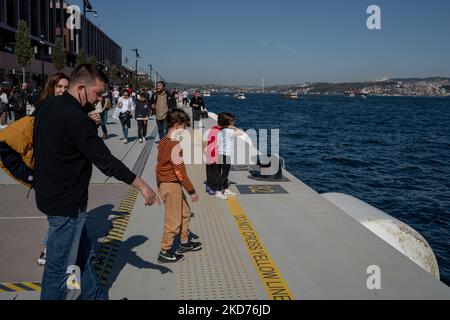 La gente cammina al porto di Galatport e guarda il Bosforo il 9 aprile 2022, a Istanbul, in Turchia. Situato nel quartiere Karakoy di Istanbul, il Galatport è stato progettato come un moderno porto per le grandi navi da crociera. Gli edifici storici restaurati fungono ora da ristoranti, negozi di abbigliamento e musei. (Foto di Erhan Demirtas/NurPhoto) Foto Stock