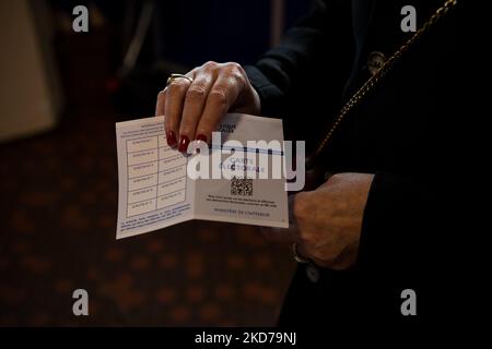 Un elettore mostra la sua carta al seggio n. 34 nel 19th° arrondissement all'apertura del primo turno delle elezioni presidenziali, a Parigi, il 10 aprile 2022. (Foto di Andrea Savorani Neri/NurPhoto) Foto Stock