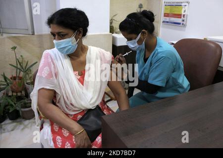 Un operatore sanitario inocula una donna con una dose precauzionale di vaccino contro il coronavirus in un ospedale di Nuova Delhi, India, il 10 aprile 2022, dopo l'annuncio da parte del governo che i colpi di richiamo pagati contro il Covid-19 saranno disponibili per tutti gli adulti presso centri privati di vaccinazione. (Foto di Mayank Makhija/NurPhoto) Foto Stock