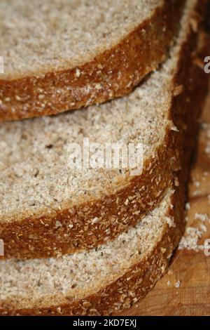 Primo piano di tre fette di pane impilate su un tavolo di legno - intero concetto di cibi salutari, alimentazione sana Foto Stock