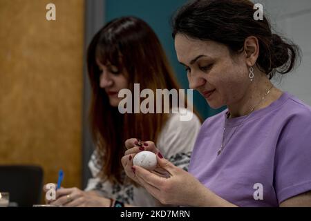 Julia Kotlinska, destra, e Kateryna Kucheruk partecipano ad un laboratorio di Pysanka all'Università nordorientale, in vista della Pasqua Ucraina. I disegni sono disegnati con cera e le uova sono tinte in strati, cominciando con il colore più chiaro e lavorando fino al rosso o nero. Alla fine, la cera viene rimossa per rivelare un uovo finemente decorato. (Foto di Jodi Hilton/NurPhoto) Foto Stock