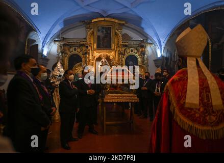 Arcivescovo di Cusco, Richard Daniel Alarcón Urrutia, prega con il gruppo di devoti di fronte al Santo Sepolcro (una statua a grandezza naturale del corpo crocifisso di Gesù in una bara di vetro) e alla Vergine dolorosa (Madonna Addolorata), All'interno del chiostro principale della basilica durante le celebrazioni del Venerdì Santo nella Basilica di la Merced a Cusco. La processione ufficiale a Plaza De Armas a Cusco è stata annullata a causa della pandemia del Covid-19. Venerdì 15 aprile 2022 a Cusco, Perù. (Foto di Artur Widak/NurPhoto) Foto Stock