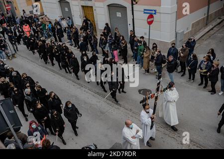 La croce tenuta dalle altariste con le donne dopo il sabato Santo durante la processione della Desolata a Canosa di Puglia il 16 aprile 2022. La Processione della desolazione è uno dei più importanti e significativi riti religiosi della settimana Santa a Canosa di Puglia, che si svolge il sabato Santo. L'elemento più suggestivo che da sempre contraddistingue questa Processione è rappresentato dal coro composto da donne vestite di nero, che da oltre 50 anni è diretto continuamente dal Maestro Mimmo Masotina, ora dal figlio Ezio, che canta l'Inno del desolato, esprimendosi all'unisono Foto Stock