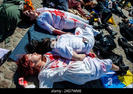 Un gruppo di donne ucraine coperte di sangue falso giace sul terreno di fronte alla piazza Dam di Amsterdam, per protestare contro la guerra della Russia in Ucraina, il 17th aprile 2022. (Foto di Romy Arroyo Fernandez/NurPhoto) Foto Stock