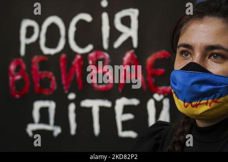 Un manifestante che indossa una maschera di bandiera Ucraina con il messaggio " Nessuna guerra " durante una manifestazione contro l'invasione russa dell'Ucraina e la morte di bambini nella città di Mariupol fuori dall'ambasciata russa a Bangkok il 20 aprile 2022. (Foto di Anusak Laowilas/NurPhoto) Foto Stock