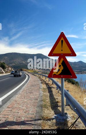 Segnale di avvertimento sul lato destro della strada. Grecia. Cadute Rocks.Lesbos viste. Segnali. Triangoli gialli e rossi. Data settembre 2022 Foto Stock