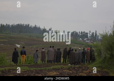 La gente di Kashmiri guarda verso l'area residenziale dove l'incontro è seguito nel distretto di Baramulla di indiano amministrato Kashmir il 22 aprile 2022. Tre militanti sono stati uccisi in una battaglia di 40 ore tra forze indiane e militanti. Tre case residenziali sono state danneggiate durante l'operazione. (Foto di Muzamil Mattoo/NurPhoto) Foto Stock