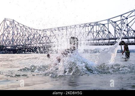 Un ragazzo salto fiume ganga e sul retro Howrah Bridge durante il caldo tempo, Kolkata temperatura massima a Kolkata probabile toccare 40 gradi il 26,2022 aprile. Il Dipartimento Meteorologico dell'India (IMD) Lunedi ha emesso un avviso di onda di calore su diversi distretti del Bengala Occidentale dal 25 aprile al 28 aprile e ha chiesto ai residenti dello stato di evitare l'esposizione prolungata al calore. (Foto di Debajyoti Chakraborty/NurPhoto) Foto Stock