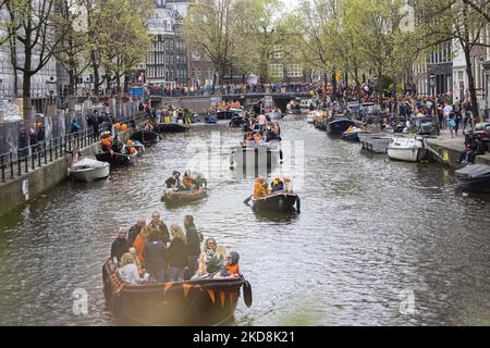 I Paesi Bassi festeggiano il King's Day dopo due anni di cancellazione a causa della pandemia di Coronavirus COVID-19 e delle restrizioni e misure di blocco. Migliaia di locali e visitatori hanno visitato i canali di Amsterdam per celebrare con varie feste il compleanno di Re Willem-Alexander conosciuto come Koningsdag, una festa nazionale olandese. Tutti i tipi di barche e navi sono visti nei canali che passano sotto i famosi ponti e vicino alle case strette di Amsterdam con persone che ballano e divertirsi. Le barche sfilano nei canali interni della città mentre i viaggiatori si riuniscono per le strade. Du Foto Stock