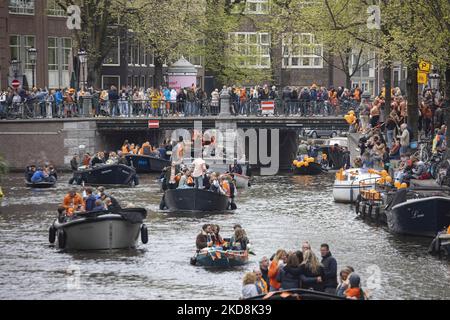 I Paesi Bassi festeggiano il King's Day dopo due anni di cancellazione a causa della pandemia di Coronavirus COVID-19 e delle restrizioni e misure di blocco. Migliaia di locali e visitatori hanno visitato i canali di Amsterdam per celebrare con varie feste il compleanno di Re Willem-Alexander conosciuto come Koningsdag, una festa nazionale olandese. Tutti i tipi di barche e navi sono visti nei canali che passano sotto i famosi ponti e vicino alle case strette di Amsterdam con persone che ballano e divertirsi. Le barche sfilano nei canali interni della città mentre i viaggiatori si riuniscono per le strade. Du Foto Stock