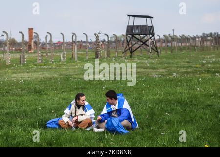 I partecipanti sono visti durante la "marcia dei vivi" presso l'ex campo di concentramento e sterminio nazista-tedesco di Auschwitz Birkenau, il 28 aprile 2022. La marcia annuale fa parte del programma educativo, che porta studenti ebrei da tutto il mondo in Polonia, dove esplorano i resti dell'Olocausto. I partecipanti marciano silenziosamente per tre chilometri da Auschwitz i ad Auschwitz II Birkenau, il più grande complesso di campi di concentramento nazisti costruito durante la seconda guerra mondiale (Foto di Beata Zawrzel/NurPhoto) Foto Stock