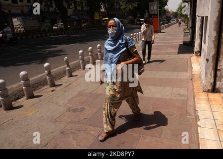 Una donna cammina con il viso completamente coperto per proteggersi dal sole duro, in una calda giornata estiva a Nuova Delhi, India, il 30 aprile 2022. (Foto di Mayank Makhija/NurPhoto) Foto Stock