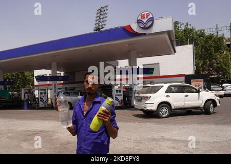 Un uomo cammina con le bottiglie d'acqua riempite ad una stazione di benzina, in una calda giornata estiva a Nuova Delhi, India il 30 aprile 2022. (Foto di Mayank Makhija/NurPhoto) Foto Stock