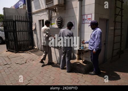 Gli uomini rifornire le loro bottiglie d'acqua in una stazione di servizio, in una calda giornata estiva a Nuova Delhi, India il 30 aprile 2022. (Foto di Mayank Makhija/NurPhoto) Foto Stock