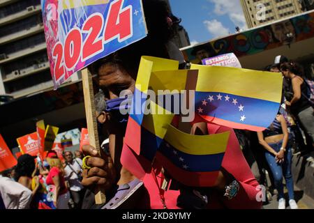 Una donna tiene bandiere venezuelane durante la marcia per celebrare la Giornata Internazionale dei lavoratori attraverso il centro di Caracas, Venezuela il 1 maggio 2022. (Foto di Javier Campos/NurPhoto) Foto Stock