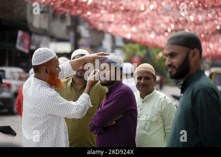 Un uomo musulmano che applica la Surma agli occhi prima di offrire la preghiera ad un Eadgah per iniziare il festival Eid al-Fitr, che segna la fine del loro santo mese di digiuno del Ramadan, a Guwahati, Assam, India, il 03 maggio 2022. (Foto di David Talukdar/NurPhoto) Foto Stock