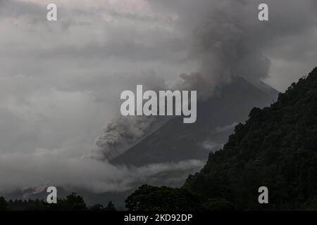 Il Monte Merapi rilascia materiale vulcanico nell'aria come visto dal villaggio di Turgo, nel distretto di Sleman a Yogyakarta, Indonesia il 23 dicembre 2021. Il vulcano del Monte Merapi è eruttato giovedì per la quarta volta in una settimana, e lo stato vulcanico del Monte Merapi è stato al livello di allerta 3 (Siaga) dal 5 novembre 2020. Mt. Merapi è uno dei vulcani più attivi in Indonesia. Un'eruzione del 2010 ha lasciato più di 300 morti e ha costretto quasi 400.000 persone a rifugiarsi. Il vulcano ha da allora continuato a rombare, spargendo cenere calda e materiale vulcanico in una serie di eruzioni nel corso dell'ultimo decennio Foto Stock