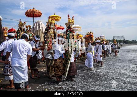 I devoti indù balinesi trasportano offerte durante il Melasti, una cerimonia di purificazione davanti a Nyepi alla spiaggia di Padang Galak a Denpasar, Bali, Indonesia 28 febbraio 2022. Il rituale Melasti si svolge ogni anno in vista del Nyepi Day of Silence, una cerimonia destinata a purificare e purificare le anime dei partecipanti indù balinesi. Nyepi è una celebrazione indù osservata ogni nuovo anno secondo il calendario balinese. La festa nazionale è uno di auto-riflessione e meditazione e attività come il lavoro, guardare la televisione, o viaggiare è limitato tra le ore 6:6 e le ore 14:00 (P Foto Stock