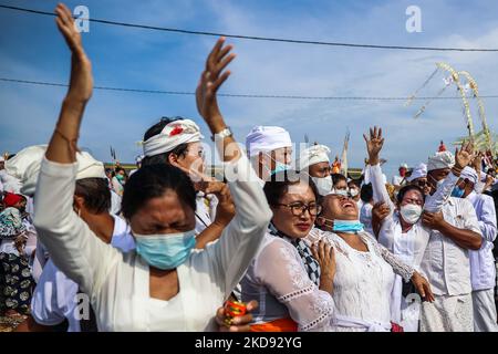 La donna indù balinese grida mentre si trova in uno stato di trance durante Melasti, una cerimonia di purificazione davanti a Nyepi alla spiaggia di Padang Galak a Denpasar, Bali, Indonesia 28 febbraio 2022. Il rituale Melasti si svolge ogni anno in vista del Nyepi Day of Silence, una cerimonia destinata a purificare e purificare le anime dei partecipanti indù balinesi. Nyepi è una celebrazione indù osservata ogni nuovo anno secondo il calendario balinese. La festa nazionale è uno di auto-riflessione e meditazione e attività come il lavoro, guardare la televisione, o viaggiare è limitato tra le ore 6 e Foto Stock