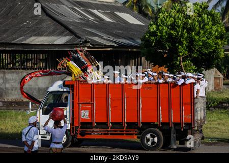 I devoti indù balinesi si riuniscono mentre eseguono preghiere durante il Melasti, una cerimonia di purificazione davanti a Nyepi in una spiaggia a Bali, Indonesia, il 1 marzo 2022. Gli indù balinesi vestiti in abiti prevalentemente bianchi trasportavano sacre effigi di dei e dee e paraphernalia rituali dai loro templi del villaggio alla spiaggia per eseguire una cerimonia di purificazione chiamata rituale Melasti. Gli indù balinesi credono che il rituale Melasti sia un must che si esibisce prima del giorno del Nyepi, il giorno del silenzio, per purificare l'anima e la natura, ricaricare il potere soprannaturale degli oggetti sacri del tempio e pulire il sistema Foto Stock