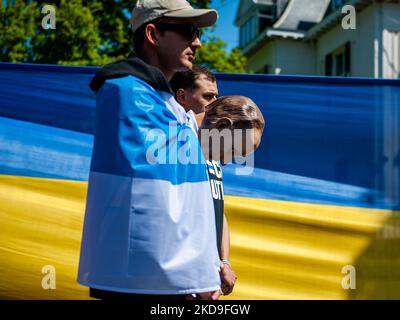 Un uomo vestito da presidente russo Vladimir Putin è ammanettato e in piedi davanti alla bandiera Ucraina, durante un processo simbolico contro di lui tenutosi all'Aia il 8th maggio 2022. (Foto di Romy Arroyo Fernandez/NurPhoto) Foto Stock