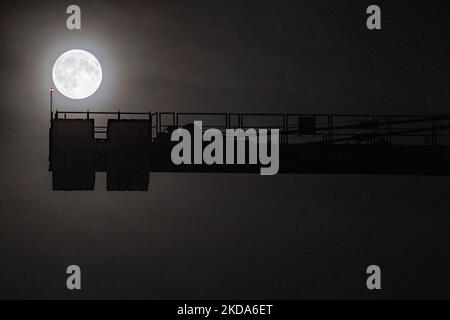 Super Fiore Luna piena del 2022. Luminosa e bella illuminazione a luna piena nel cielo scuro notturno, tradizionalmente noto come Luna dei Fiori, come si vede dalla città di Eindhoven in Europa. La Luna o Luna o Selene è un corpo astronomico, il satellite naturale della Terra, che orbita intorno al pianeta. La luna è avvistata dietro una gru da cantiere. Eindhoven, Paesi Bassi il 16 maggio 2022 (Foto di Nicolas Economou/NurPhoto) Foto Stock