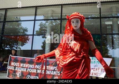 Un manifestante vestito di rosso per simboleggiare l'urgenza di agire contro le immissioni di gas riscaldanti si trova davanti a una bandiera che recita: "Non abbiamo tempo, quale futuro per i nostri figli?" LA XR France (Extinction Rebellion) e la ANV-COP21 hanno organizzato un "die-in" per protestare contro un vertice organizzato dalla TSE (Toulouse School of Economics) chiamato "Common Goods Summit" con il CEO di ExxonMobil Europe, il CEO di AXA France tra gli altri. Il tema è l'energia 'verde' (idrogeno, gas naturale) e la mitigazione dei cambiamenti climatici. XR e ANV-COP21 denunciano la presenza di ExxonMobil (che possiede diversi 'Clim Foto Stock