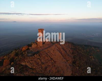 Un colpo d'aria delle rovine di un castello medievale con due torri sulla cima del monte Hazmburk nella Repubblica Ceca Foto Stock