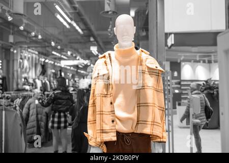 Negozio di abbigliamento per uomo e donna. Manichini vestiti con abiti da donna eleganti e luminosi invernali in un negozio commerciale. Foto Stock