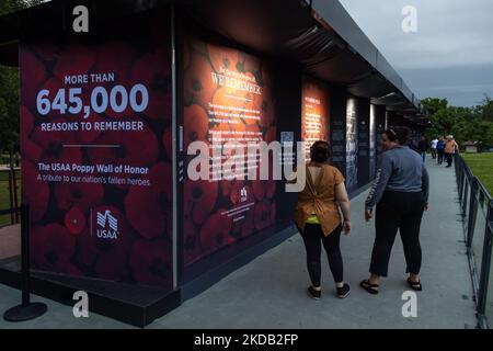 Le persone visitano il Muro d'onore dei papaveri dell'USAA, un tributo che contiene più di 645.000 papaveri artificiali in onore dei membri del servizio persi in servizio dopo la prima guerra mondiale, Che è tornato al National Mall a Washington, D.C. il 27 maggio 2022 dopo un periodo di sospensione di tre anni (Foto di Bryan Olin Dozier/NurPhoto) Foto Stock