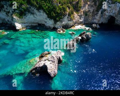 Una vista dall'alto dell'isola di Antipaxos con ripide scogliere bianche e grotte in Grecia e acque cristalline del mare Foto Stock