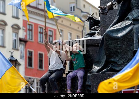 I bambini hanno bandiere ucraine e, come gli ucraini e i polacchi dimostrano nella Piazza dei Marker di Cracovia, in Polonia, per esprimere il loro desiderio di un maggiore sostegno all'Ucraina, che è sotto l'assedio dell'esercito russo il 31 maggio 2022. Mentre la Federazione Russa invase l'Ucraina, il conflitto ha costretto 6,8 milioni di ucraini a fuggire dal loro paese, molti civili sono stati uccisi e la Russia è sottoposta a un'indagine sui suoi presunti crimini di guerra. (Foto di Dominika Zarzycka/NurPhoto) Foto Stock