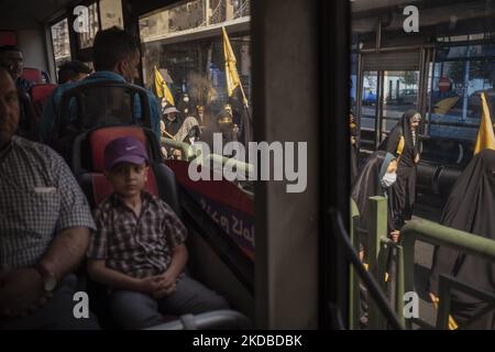 Persone in un autobus come un gruppo di studenti universitari iraniani Basiji (membri della forza paramilitare Basij) che portano bandiere gialle in un rally per celebrare il trentatreesimo anniversario di morte del fondatore della Repubblica islamica, Ayatollah Ruhollah Khomeini, nel centro di Teheran il 3 giugno 2022. (Foto di Morteza Nikoubazl/NurPhoto) Foto Stock